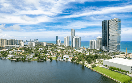 3. Overhead perspective of a northern Florida city skyline, with buildings mirrored in the calm water below, capturing the landscape.