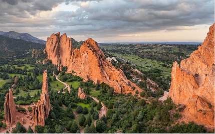 Scenic view of Garden of the Gods in Colorado, featuring striking red rock formations against a clear blue sky.