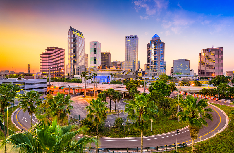 Tampa, Florida skyline at sunset, showcasing vibrant colors and silhouettes of buildings against a dusky sky.