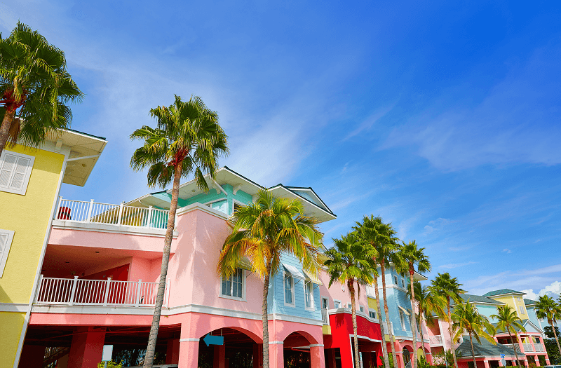 Tall palm trees and brightly colored buildings in Fort Myers, Florida, on a bright afternoon.
