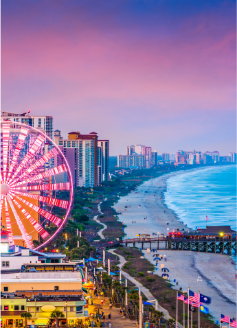 An aerial view of the coast of Myrtle Beach at dusk with its famous ferris wheel in the foreground