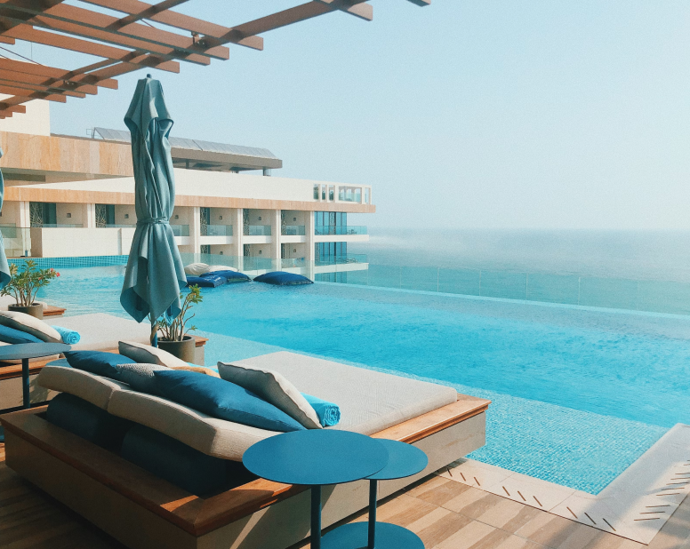 A poolside deck with loungers overlooking a beautiful resort view