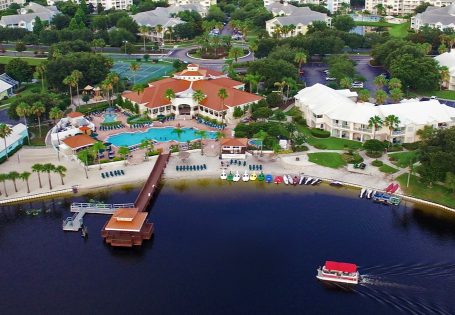 An aerial view of the Summer Bay Orlando By Exploria Resorts showing its lake with boats in the water
