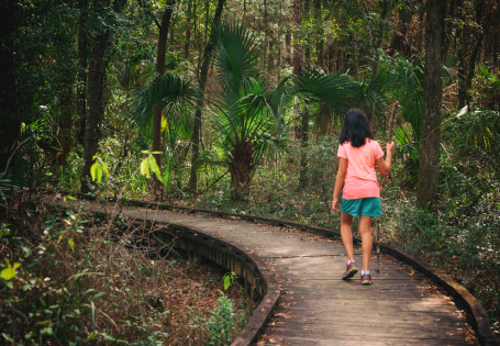 A woman walking a forest trail