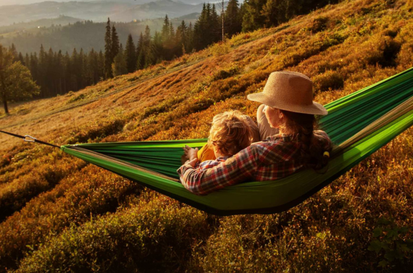 Woman and child in a hammock in the outdoors, enjoying the nature views