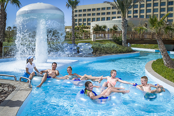 A family riding tubes in a resort pool
