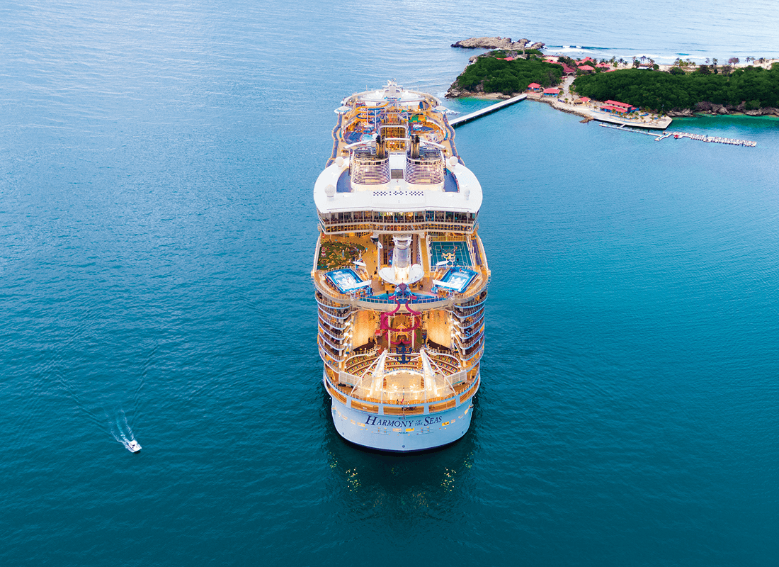  A large cruise ship sailing through the ocean under a clear blue sky.