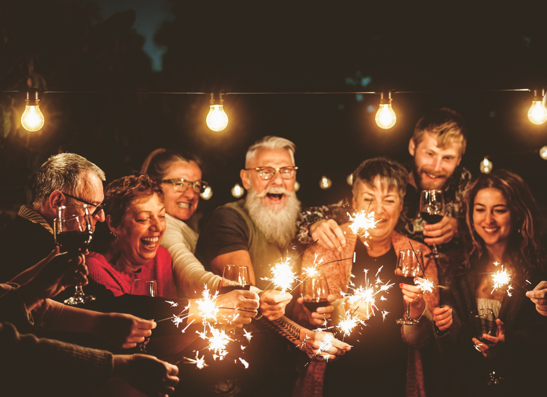 A group of people celebrating with sparklers and wine glasses.