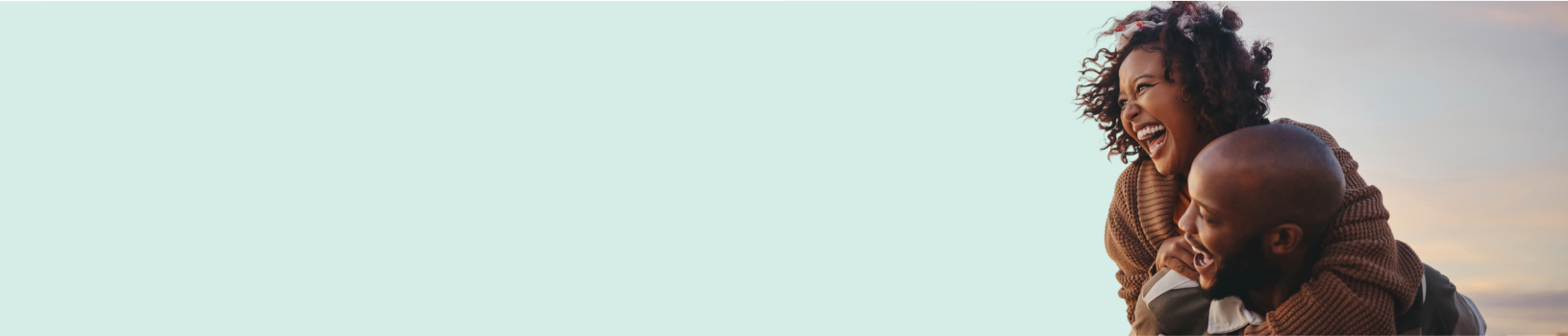 A joyful man piggybacking his smiling wife.