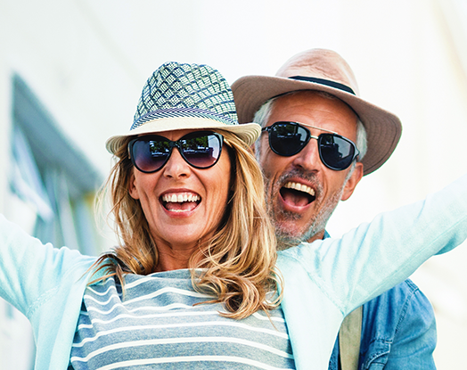 A smiling couple in sunglasses and hats