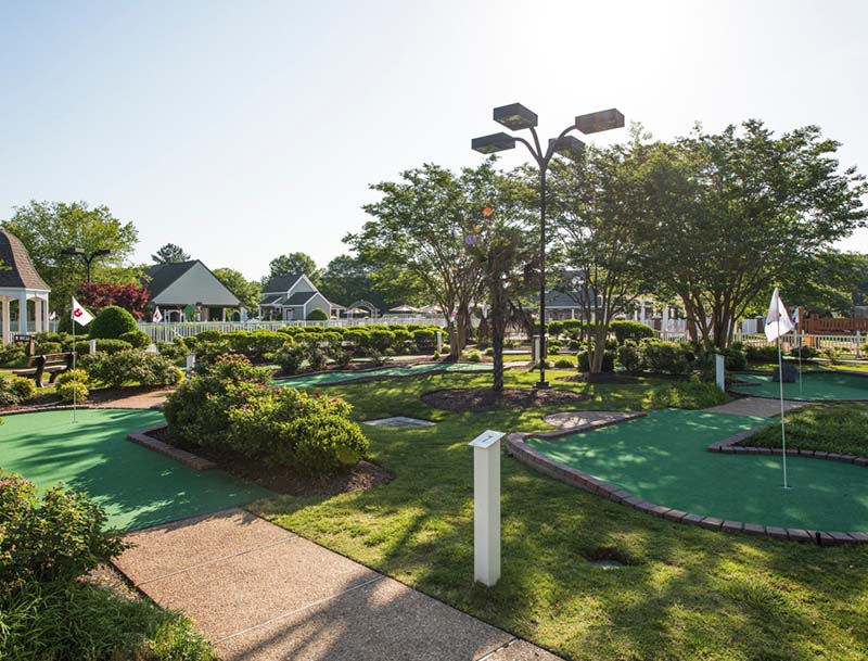 A lushly landscaped miniature golf course, with resort buildings visible in the background.