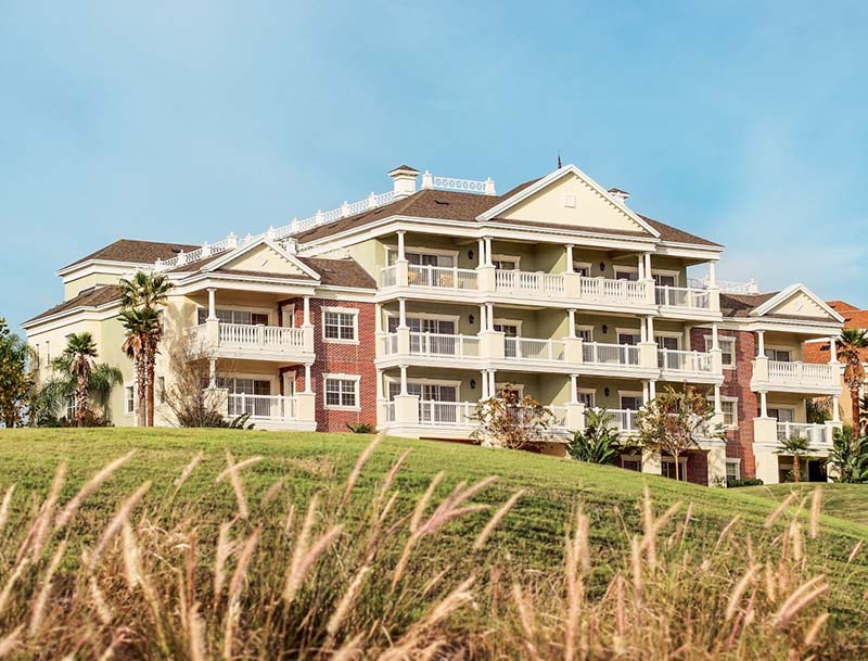 A low-angle shot of a golf course with a large resort building in the background.