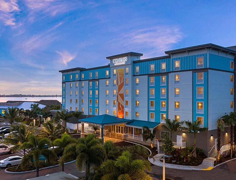 Exterior view of the hotel's colorful facade and welcoming entrance as seen at dusk.