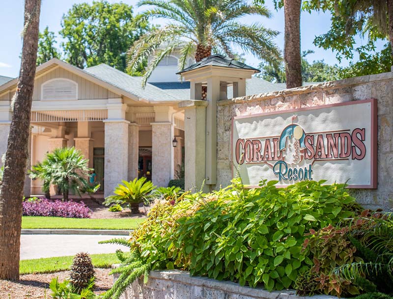 The lushly-landscaped resort entrance and signage at Coral Sands.