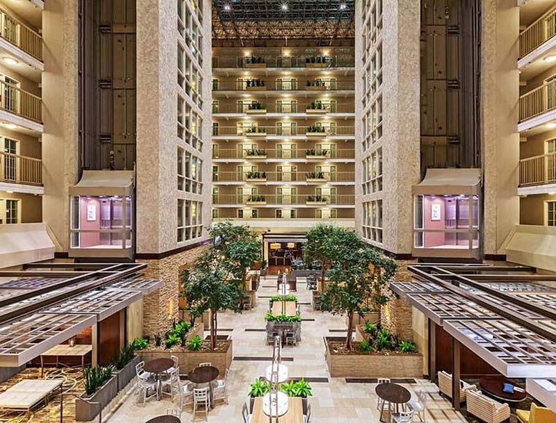 A view of the spacious hotel atrium featuring welcoming sitting areas and indoor greenery.