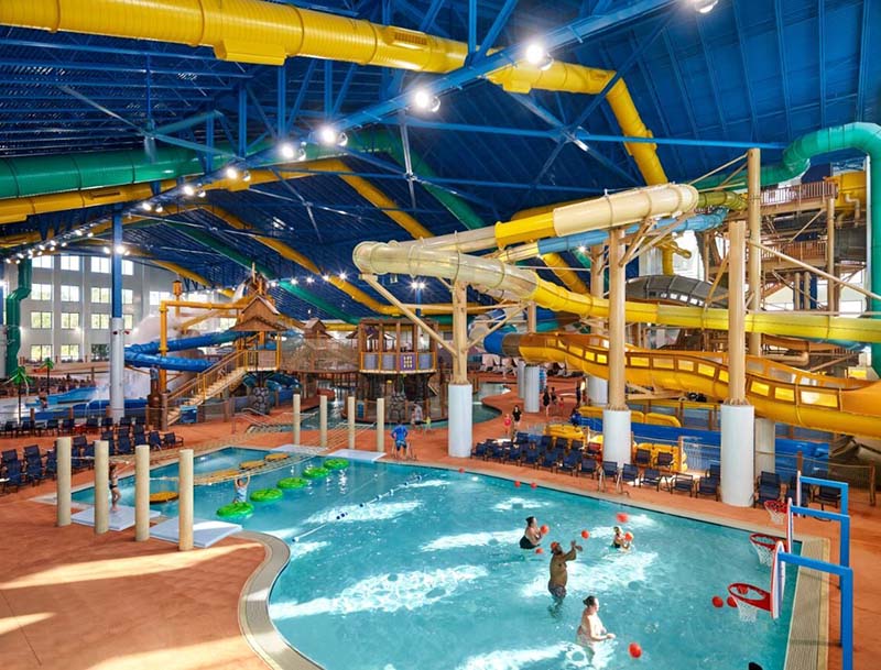 A large indoor water park featuring a pool, multiple water slides,  and other attractions for visitors of all ages.