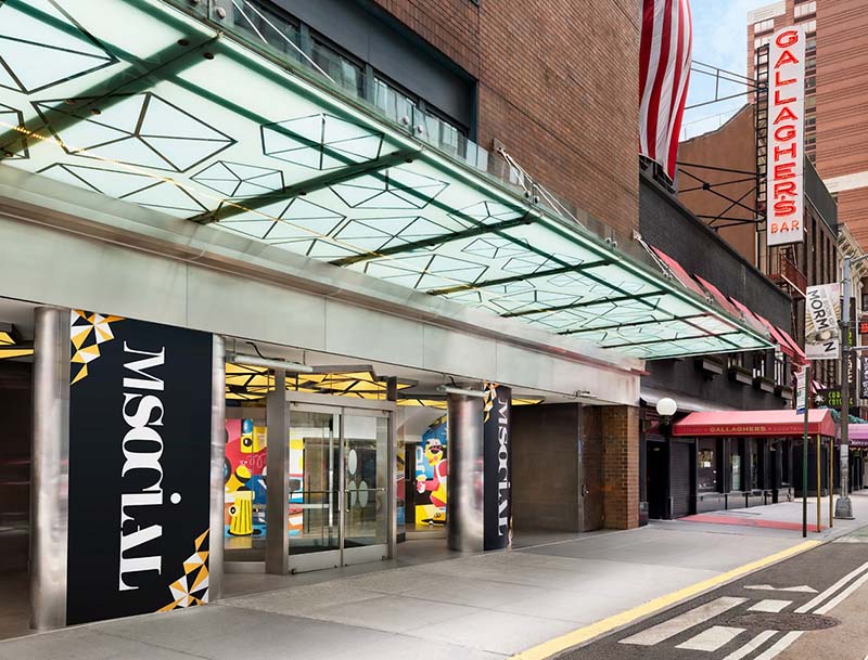 The hotel's entrance, highlighted by a modern glass canopy and prominent signage.