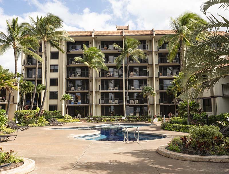 The pool area surrounded by tropical landscaping and the resort buildings.