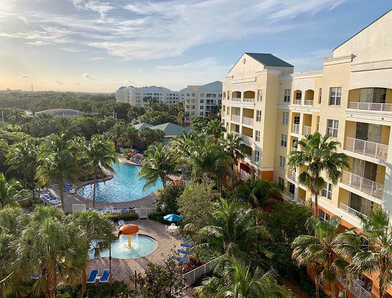 A bird's-eye view of the resort buildings and pool area nestled among lush tropical landscaping.