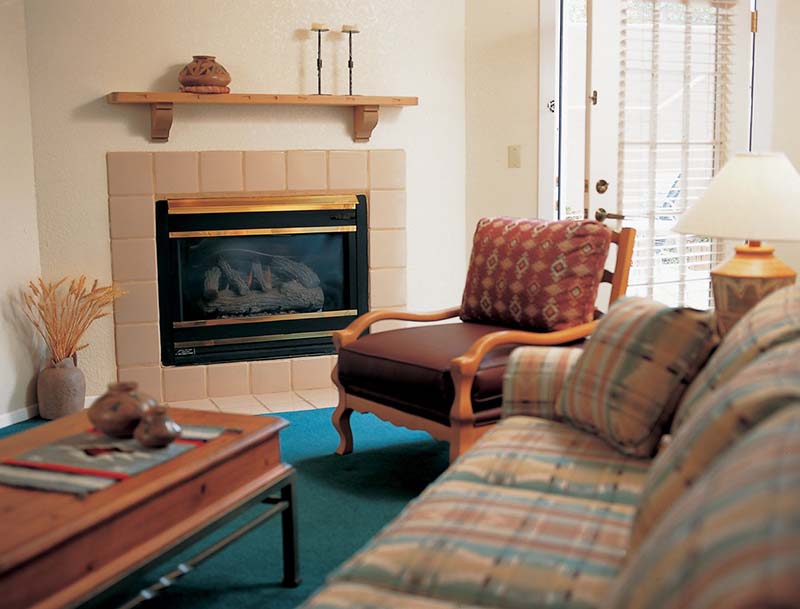 A cozy living room featuring a warm fireplace, comfortable seating, and soft lighting.