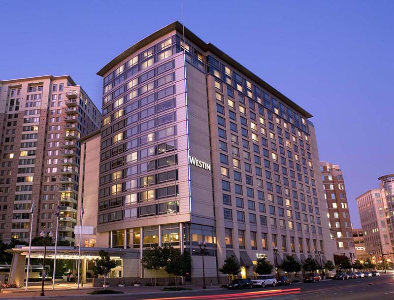 A dusk view of the hotel's illuminated facade showcasing its modern architecture and welcoming entrance.