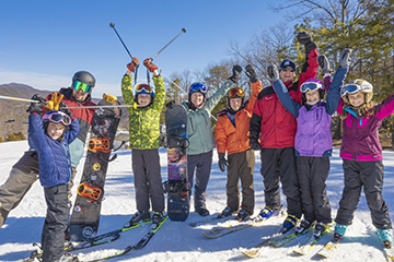 A group of skiers smiling and cheering