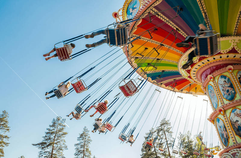 A look up at a spinning swing seat ride at an amusement park.