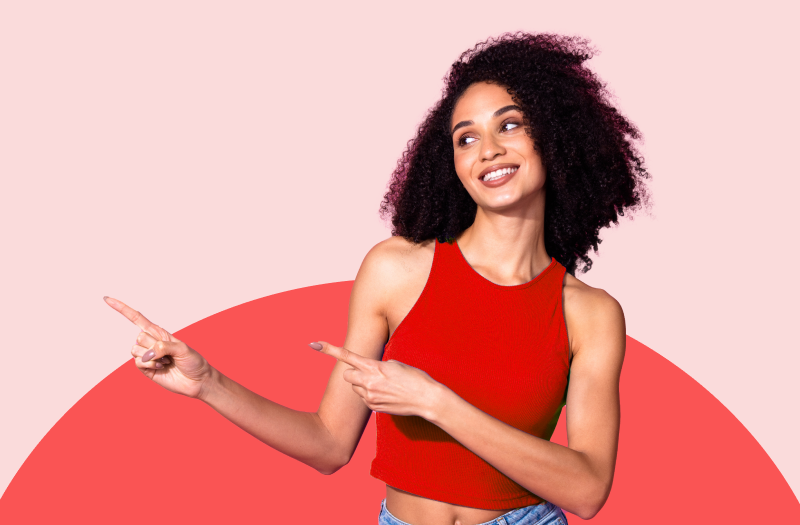 A smiling woman enthusiastically pointing to the left with both hands, on a red semicircular background.