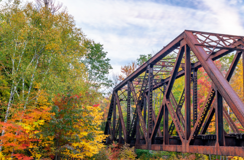 The Crawford Notch Bridge in New Hampshire surrounded by beautiful fall foliage.