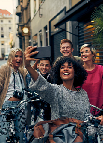A group of smiling friends on bikes taking a group picture