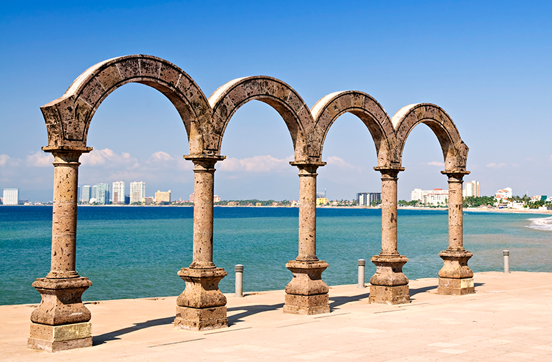 Los icónicos arcos de piedra en el Malecón de Puerto Vallarta con vista a la Bahía de Banderas en México.