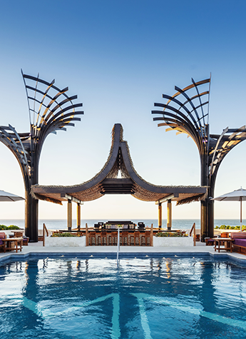 A beautiful pool hotel area with sculptures around a poolside bar