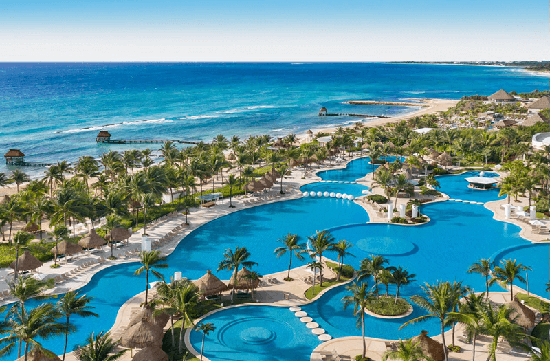 Aerial view of the beautiful ocean and stunning winding pools surrounded by lush landscaping at Mayan Palace at Vidanta Riviera Maya.
