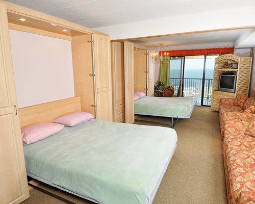 A bed room with two murphy beds with an ocean view.