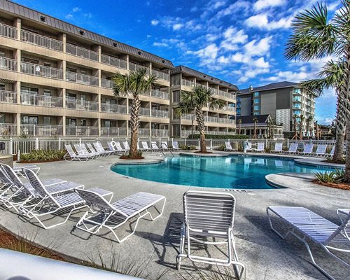 An outdoor swimming pool surrounded by poolside furniture.