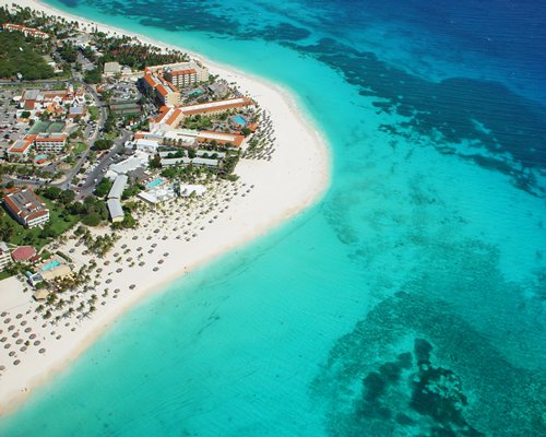An aerial view of Aruba Beach Club alongside beach and clear Caribbean waters.