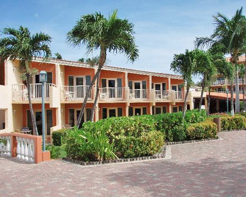 View of balconies surrounded by palm trees and shrubs.