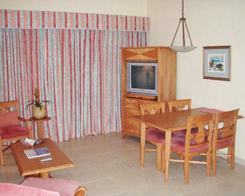 A furnished living room with dining area and television.
