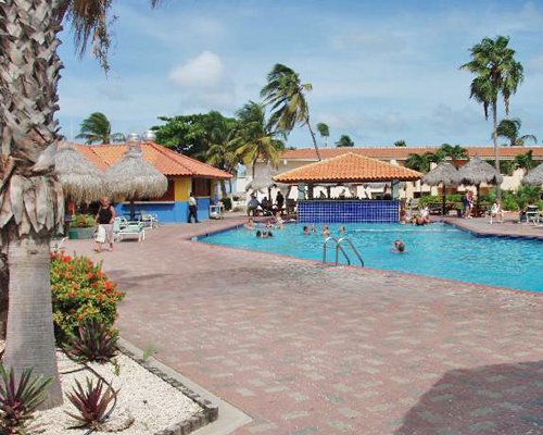 A large outdoor swimming pool near poolside bar.