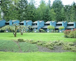 VIEW OF MULTIPLE VACATION UNITS SURROUNDED BY LAWNS AND TREES.