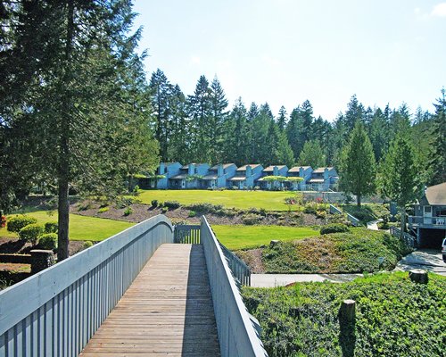 Multiple unit view of Blue Heron resort with lawn near wooded area.