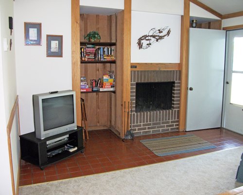 A living room with a television and a fireplace.