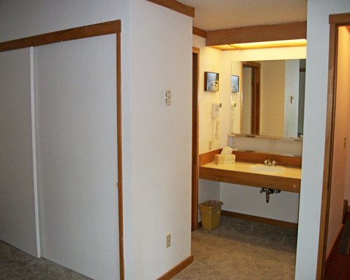 A room with an attached bathroom sink and mirror.