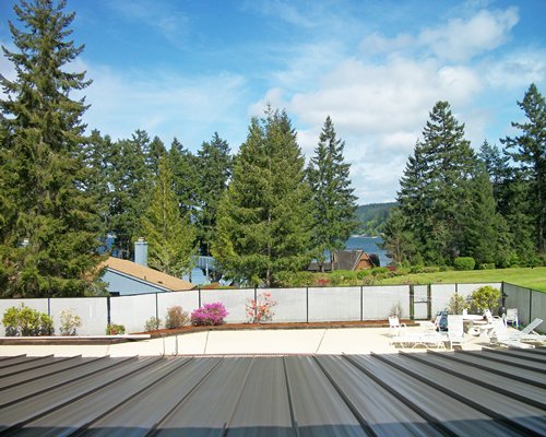 Outdoor lounge area surrounded by lawn and trees.