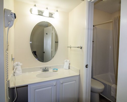 A well furnished bedroom with king bed, television and outside view.
