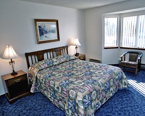 A well furnished bedroom with a queen bed and an outdoor view.