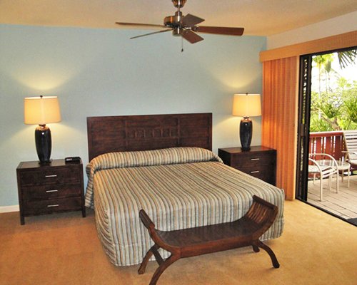 A well furnished bedroom with king bed and balcony..