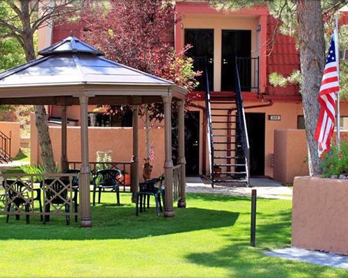 Sunshade with patio furniture alongside resort.