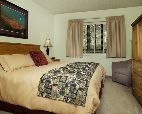 Furnished bedroom with a king bed and outside view.