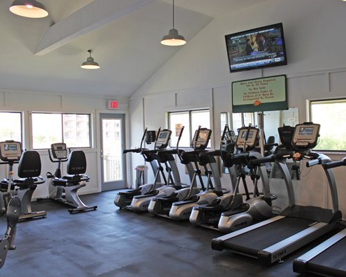 A well equipped fitness center with television.